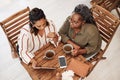 Our common interests keep us connected. High angle shot of two young women using a digital tablet together at a cafe. Royalty Free Stock Photo