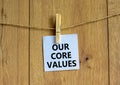 Our core values symbol. White paper with words `Our core values`, clip on wooden clothespin. Beautiful wooden background. Busine Royalty Free Stock Photo