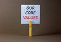 Our core values symbol. White paper with words `Our core values`, clip on wooden clothespin. Beautiful grey background. Business Royalty Free Stock Photo