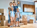 Our family is one strong unit. Portrait of a cheerful young family standing together in their new home inside during the Royalty Free Stock Photo