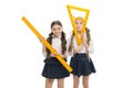Our favorite lesson. Little girls preparing for geometry lesson. Cute schoolgirls holding triangular and ruler for
