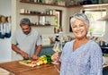 Our favorite thing to do at home is cook. Portrait of a happy mature woman enjoying a glass of wine while her husband Royalty Free Stock Photo