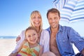 Our holiday house is just off the coast. a happy young family sitting together under a beach umbrella. Royalty Free Stock Photo