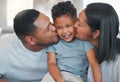 In our home, we smooch. a young family bonding with their son on the sofa at home.