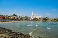 Our Lady of Ransom Shrine Church behind colorful houses on a sand beach occupied by fishing boats in Kanyakumari in India Royalty Free Stock Photo