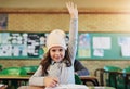 Our little genius in the class. Portrait of an adorable elementary schoolgirl raising her hand in class. Royalty Free Stock Photo
