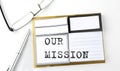 OUR MISSION text on sticky notes with glasses and pen, business concept Royalty Free Stock Photo