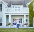 This is our new home. a young family posing in front of a house with a sold sign. Royalty Free Stock Photo