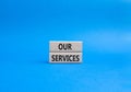 Our services symbol. Concept words Our services on wooden blocks. Beautiful blue background. Business and Our services concept.