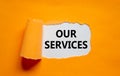 Our services symbol. The words `our services` appearing behind torn orange paper. Beautiful background. Business and our service