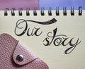 Our Story words lettering in copybook and wallet. Business story concept