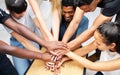 Our team will be number one. a group of coworkers huddling their hands together in a team sprit huddle.