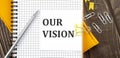 OUR VISION text on a sticker on the notebook, wooden background Royalty Free Stock Photo