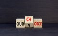 Our voice choice symbol. Businessman turns wooden cube and changes concept word Our choice to Our voice. Beautiful black table