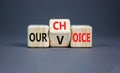 Our voice choice symbol. Businessman turns wooden cube and changes concept word Our choice to Our voice. Beautiful grey table grey