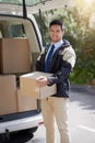 From our warehouse to your door. Portrait of a friendly delivery man unloading cardboard boxes from his van.