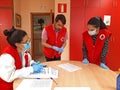 Ourense, Spain; may, 4, 2020: Red Cross technicians and volunteers with gloves and masks speak and meet for the distribution of