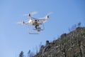 Ourense, Spain 03-03-2023: a Phantom 4 Pro drone in flight, green trees in the background, selective focus on the drone. Royalty Free Stock Photo