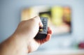 blurry Close up male hand holding remote control pointing to change the programme television in the hotel room Royalty Free Stock Photo