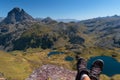 Out of focus boots of a hiker atop Ayous peak overlooking Ayous mountain lake and the Pyrenees mountains with Midi d`Ossau in
