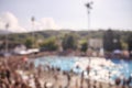 Out of focus, defocused shot, group of unrecognizable people outdoors, large crowd, swimming pool,