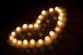 Out of focus heart shape arrangement of burning tea lights on a dark background. 9 Royalty Free Stock Photo