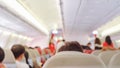 Out of focus , Interior of airplane with passengers people on seats and stewardess in uniform walking the aisle waiting for takeo