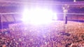 Out of focus image of big crowd of fans sitting on stadium seats watching and listening rock concert at night. Royalty Free Stock Photo