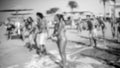 Out of focus image of cheerful young people dancing and having fun on the sea beach disco party. Silhouette of big crowd Royalty Free Stock Photo