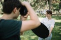 Out of focus photographer taking photos of woman in park Royalty Free Stock Photo