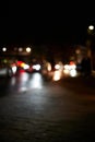 Out of focus view of cars passing at street level at night