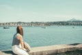 out-of-focus woman observing a bay with seafaring ships