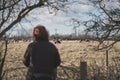 Out of focus woman seen looking at a distant herd of Alpaca`s seen at an Alacpa farm.