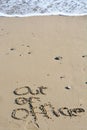 Out of office text written in sand on a beach Royalty Free Stock Photo