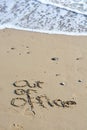 Out of office text written in sand on a beach Royalty Free Stock Photo