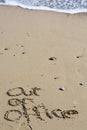 Out of office text written in sand on a beach Royalty Free Stock Photo