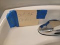 out of order sign taped to sink in bathroom or restroom Royalty Free Stock Photo