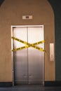 Out of service elevator with yellow tape warning signs