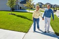 Out for a stroll in the suburbs. a happy senior couple waking around their neighborhood together.