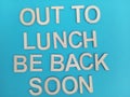 Out to lunch be back soon sign on a blue background Royalty Free Stock Photo