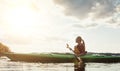 Out on the water all by myself. a young woman kayaking on a lake.