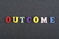 OUTCOME word on black board background composed from colorful abc alphabet block wooden letters, copy space for ad text. Learning