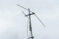 An outdoor access point attached on a traditional television antenna mounted on a roof. Overcast weather