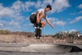 Young skateboarder man does a trick called `Nose grab` on the edge of a pool in a skate park. Royalty Free Stock Photo