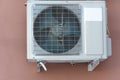 An outdoor air conditioner unit installed on the outer wall of a residential building. The fan and the radiator grille of the air Royalty Free Stock Photo