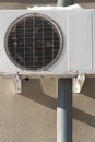 An outdoor air conditioner unit installed on the outer wall of a residential building. The fan and the radiator grille of the air Royalty Free Stock Photo