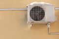 An outdoor air conditioner unit installed on the outer wall of a residential building. The fan and the radiator grille of the air Royalty Free Stock Photo