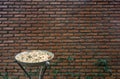 Outdoor metal ashtray with red brick wall background