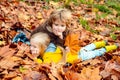 Outdoor autumn portrait of little girl and boy laying in autumn park. Fall leaves relaxing and still life kids concept. Royalty Free Stock Photo
