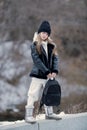 Outdoor autumn portrait of young fashionable happy girl wearing black coat, hat, with black backpack, posing in street of European Royalty Free Stock Photo